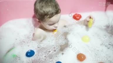 晚上洗澡时，小男孩在有泡沫的水里玩玩具